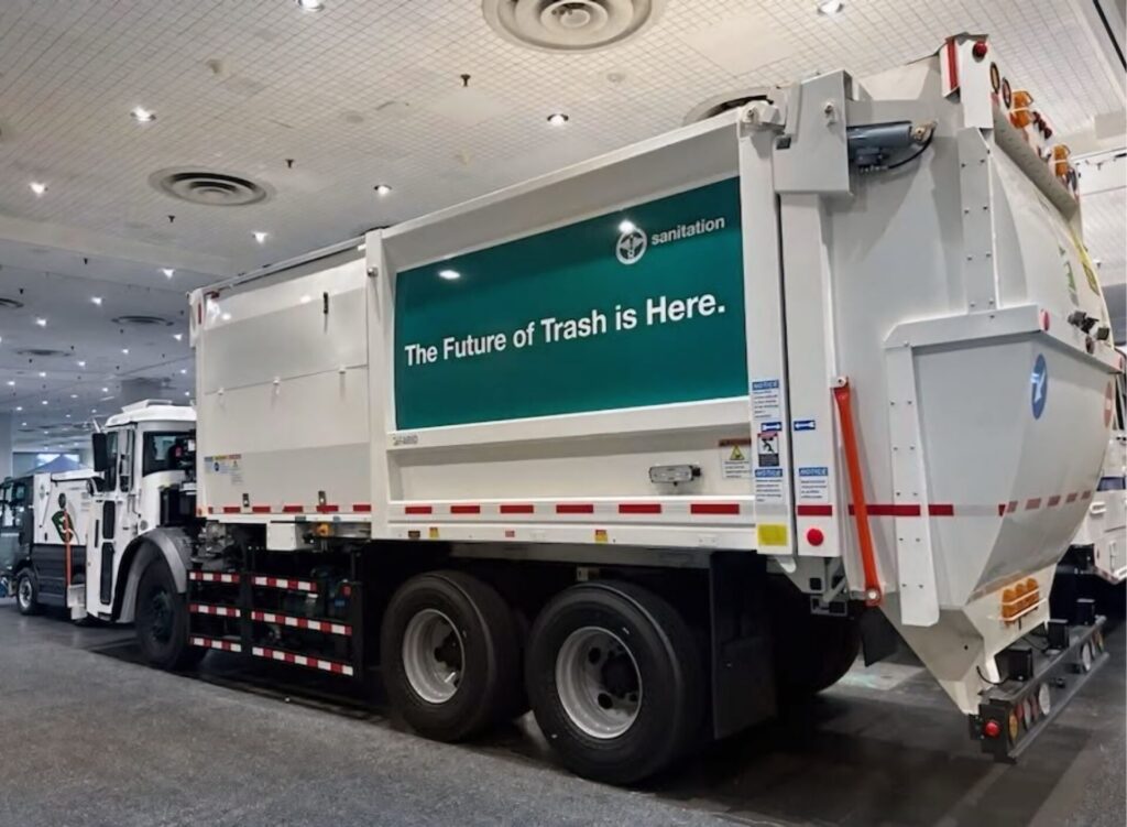 DSNY truck with advertisement on side stating “The Future of Trash is Here”